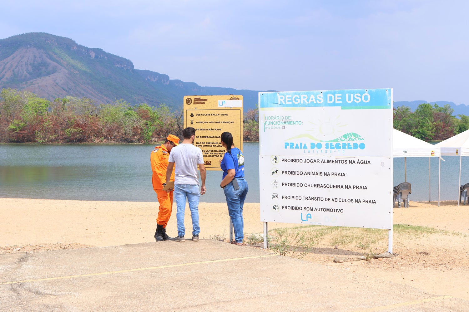 Firefighters and the Secretary of Tourism check the signage plaques on the beach