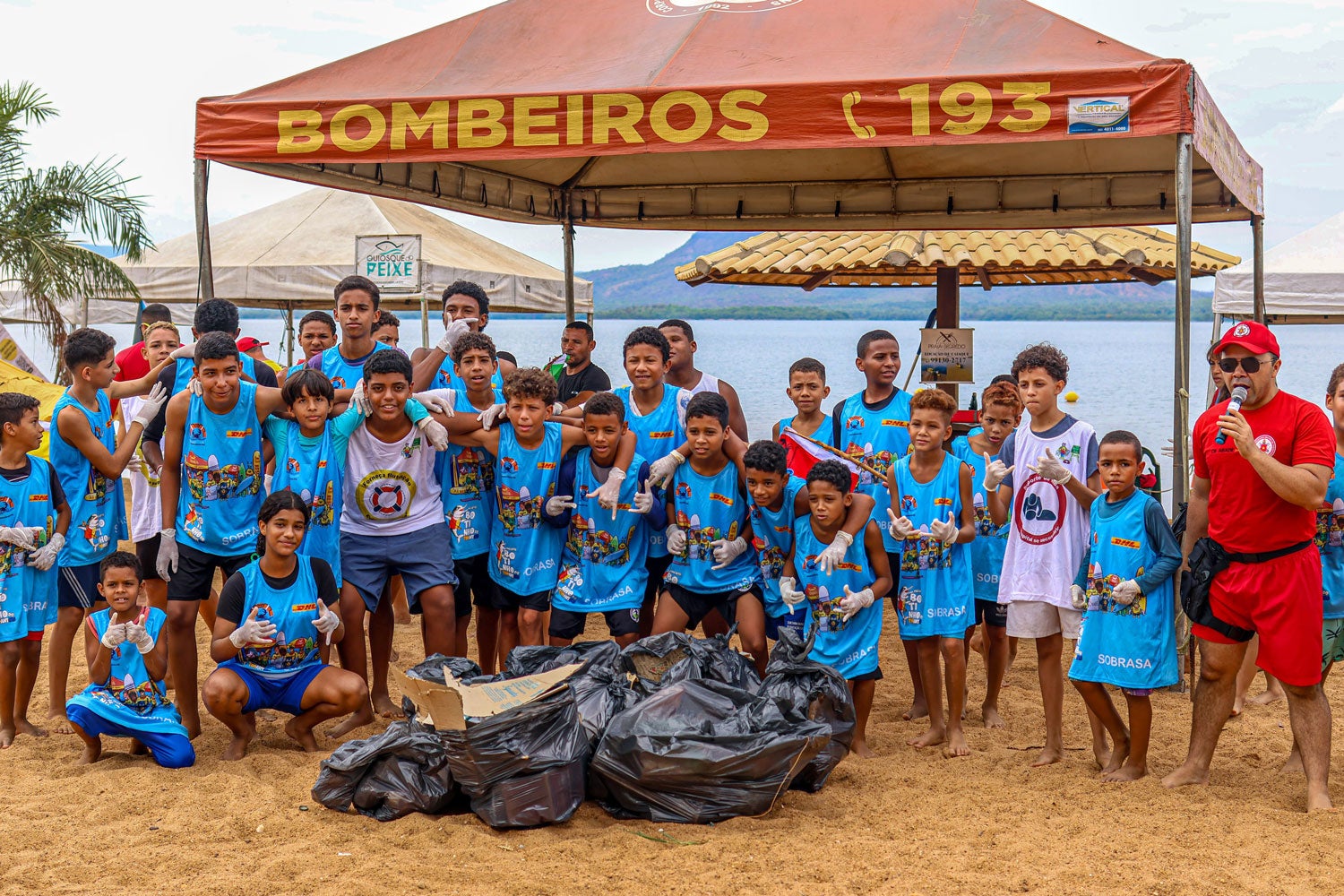Children pose for a photo after completing the task of collecting trash from the beach.