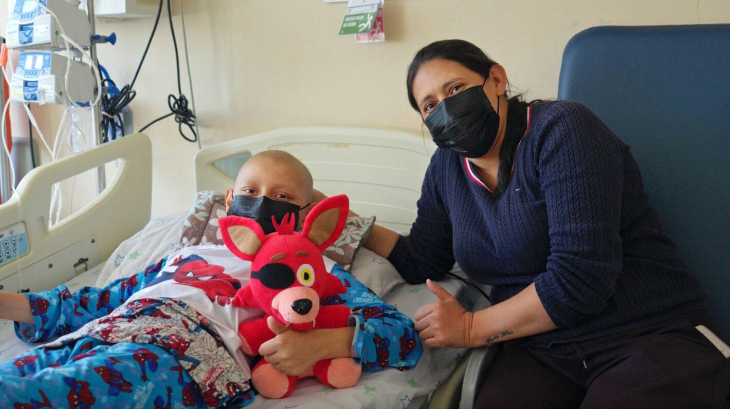 Mãe com filho, que está em uma cama de hospital