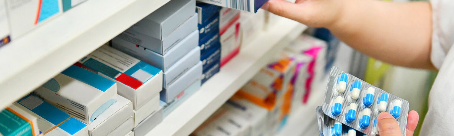 Pharmacist holding medicine box and capsule pack stock photo